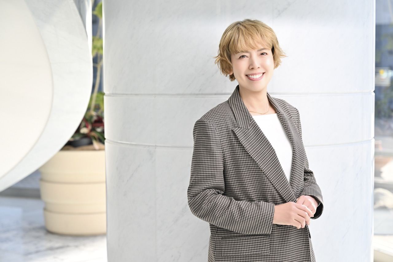 大理石のロビーで柔らかく微笑む山下亜紀の写真